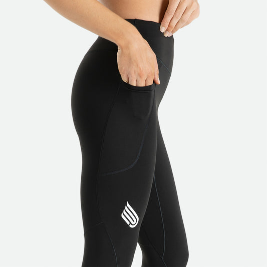 Pressio tights for dame i fargen svart. Mid-rise. På modell fra siden. Viser mobillomme på lår.
