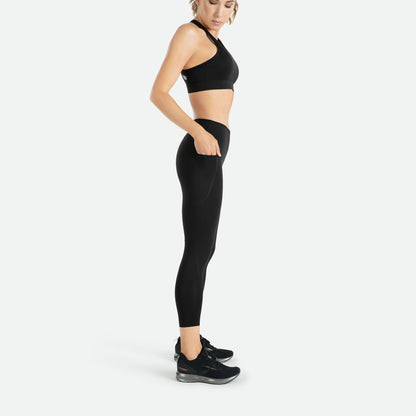 Pressio 7/8 tights for dame i fargen svart. Mid-rise. På modell fra siden. Viser mobillomme på lår.