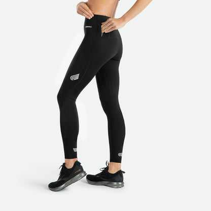Pressio thermal løpetights for dame i fargen svart. Low-rise. Fra siden og viser liten lomme på modell med glidelås.
