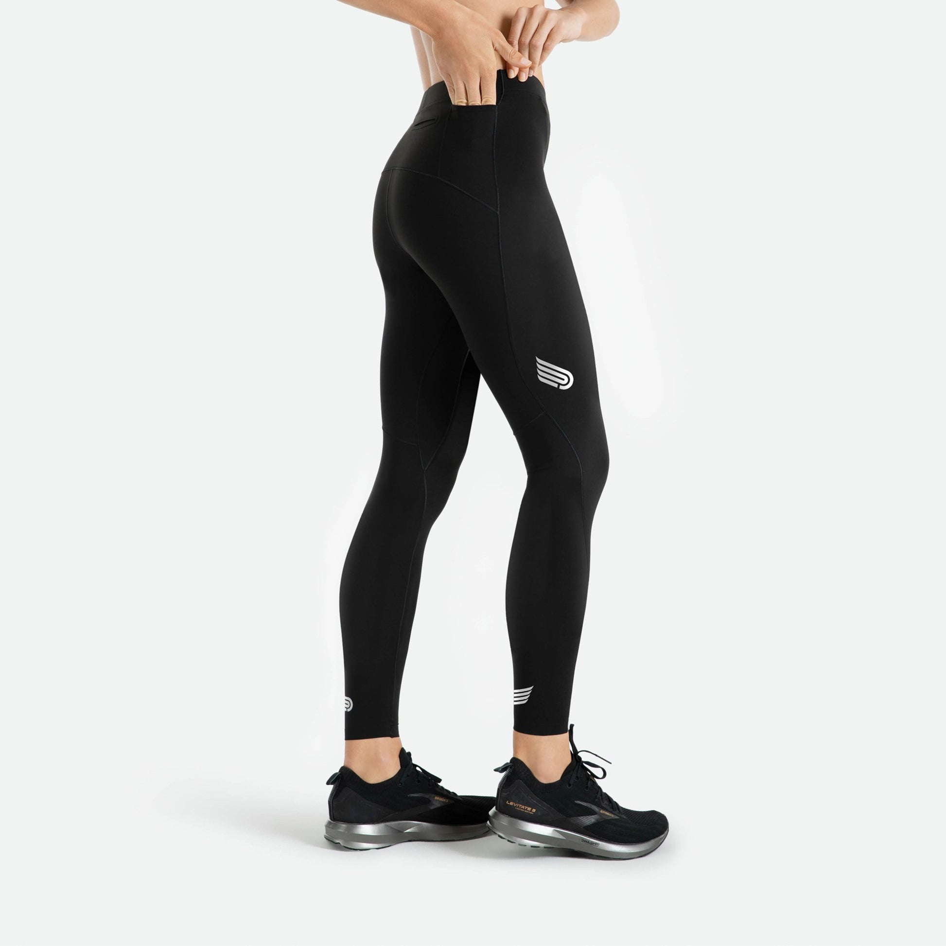 Pressio thermal løpetights for dame i fargen svart. Low-rise. Fra siden. Viser liten lomme på siden til f.eks. energigel. Nærbilde på modell.