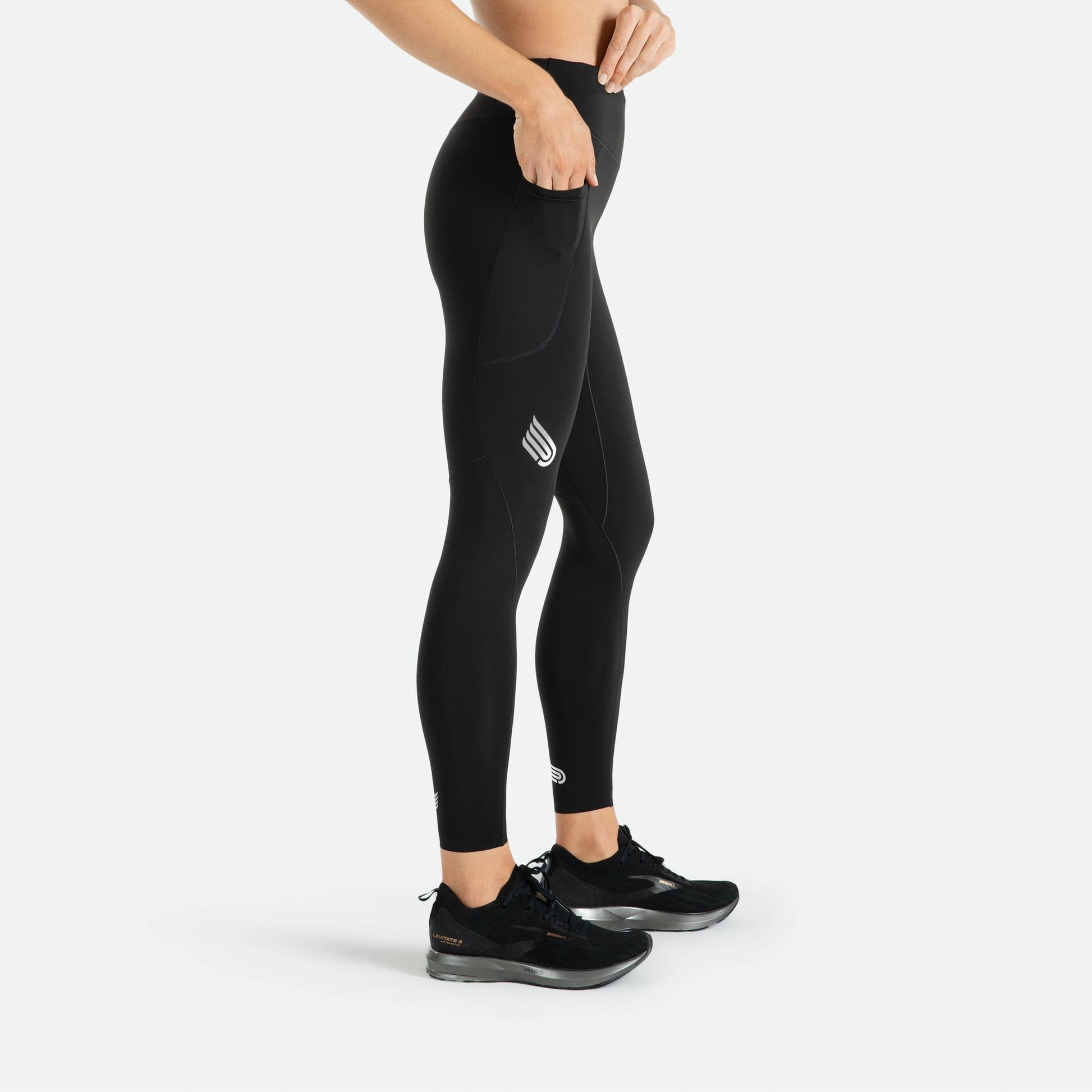 Pressio thermal tights for dame i fargen svart. Mid-rise. På modell fra siden. Vser lomme til f.eks mobil på låret.